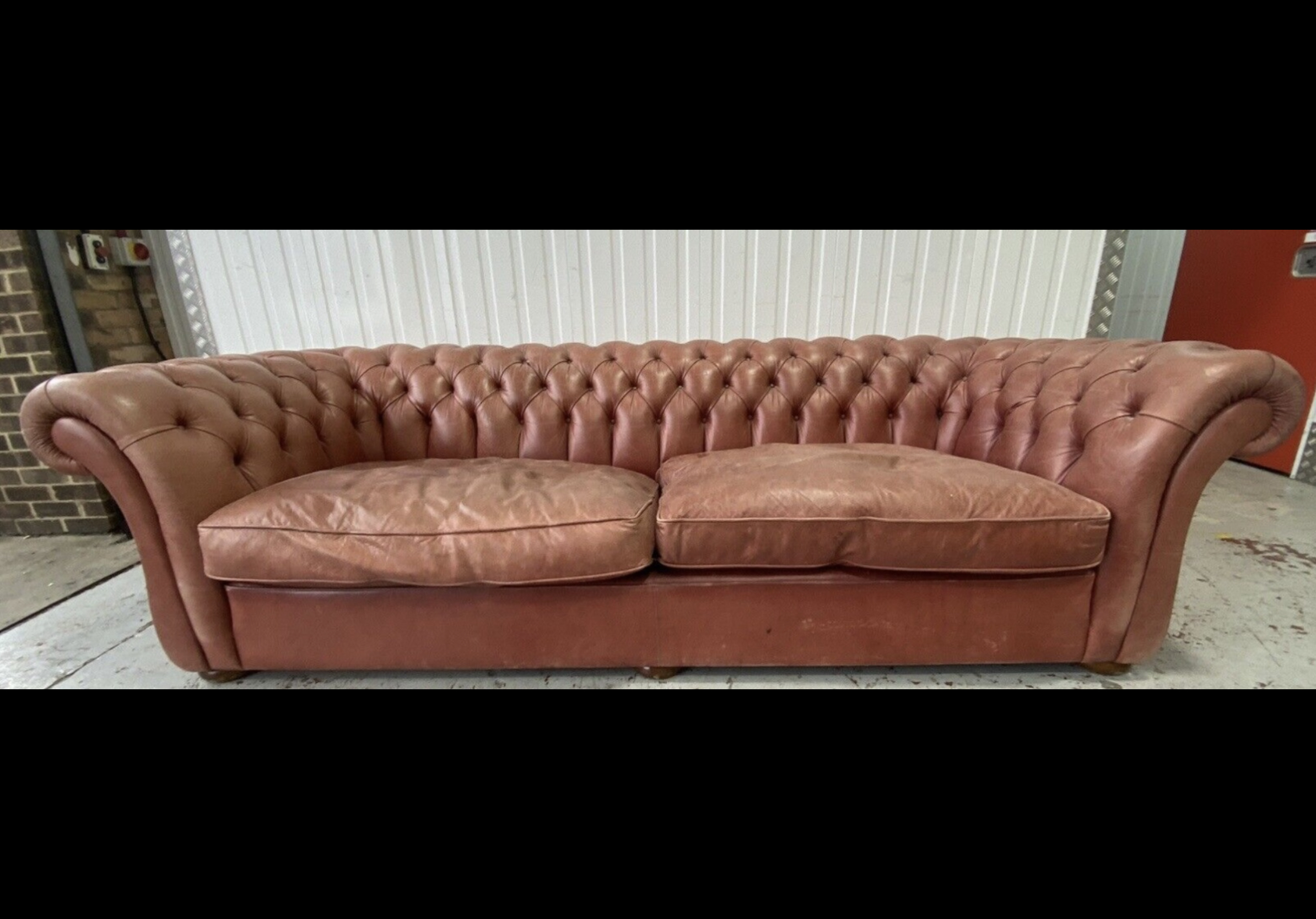 A large Victorian style buttoned back pale red leather Chesterfield settee, width 270cm, depth 104cm, height 76cm